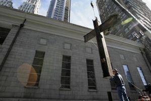 
The T-shaped steel beam that gained fame as the ground zero cross is lifted to its temporary home in New York on Thursday. The 2-ton steel cross was found in the rubble of the World Trade Center. 
 (Associated Press / The Spokesman-Review)