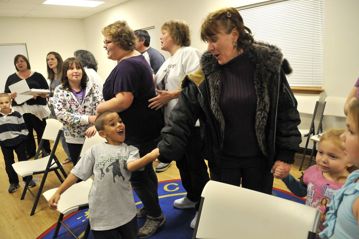 Bridget Bradick, right, holds hands with her son Nate, 6, and sings with the Voiceless Choir, a group of families that have been homeless. (Jesse Tinsley)