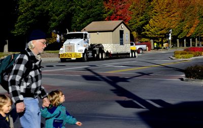 Folks milled around downtown Coeur d’Alene while the new police and fire public safety building was moved to its spot in Coeur d’Alene City Park Oct. 22.   (Kathy Plonka / The Spokesman-Review)