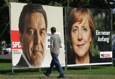 
An unidentified man walks pasts election campaign posters of German Chancellor Gerhard Schroeder and his challenger Angela Merkel in Berlin on Friday. 
 (Associated Press / The Spokesman-Review)
