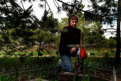Anita Kronvall, of Rathdrum, kneels Monday near a memorial  she built in her front yard in honor of her daughter, Carla James, who was killed by an impaired driver in 2002. Kronvall  has been crusading against impaired driving ever since and wants to start a chapter of Mothers Against Drunk Driving. 
 (Kathy Plonka / The Spokesman-Review)