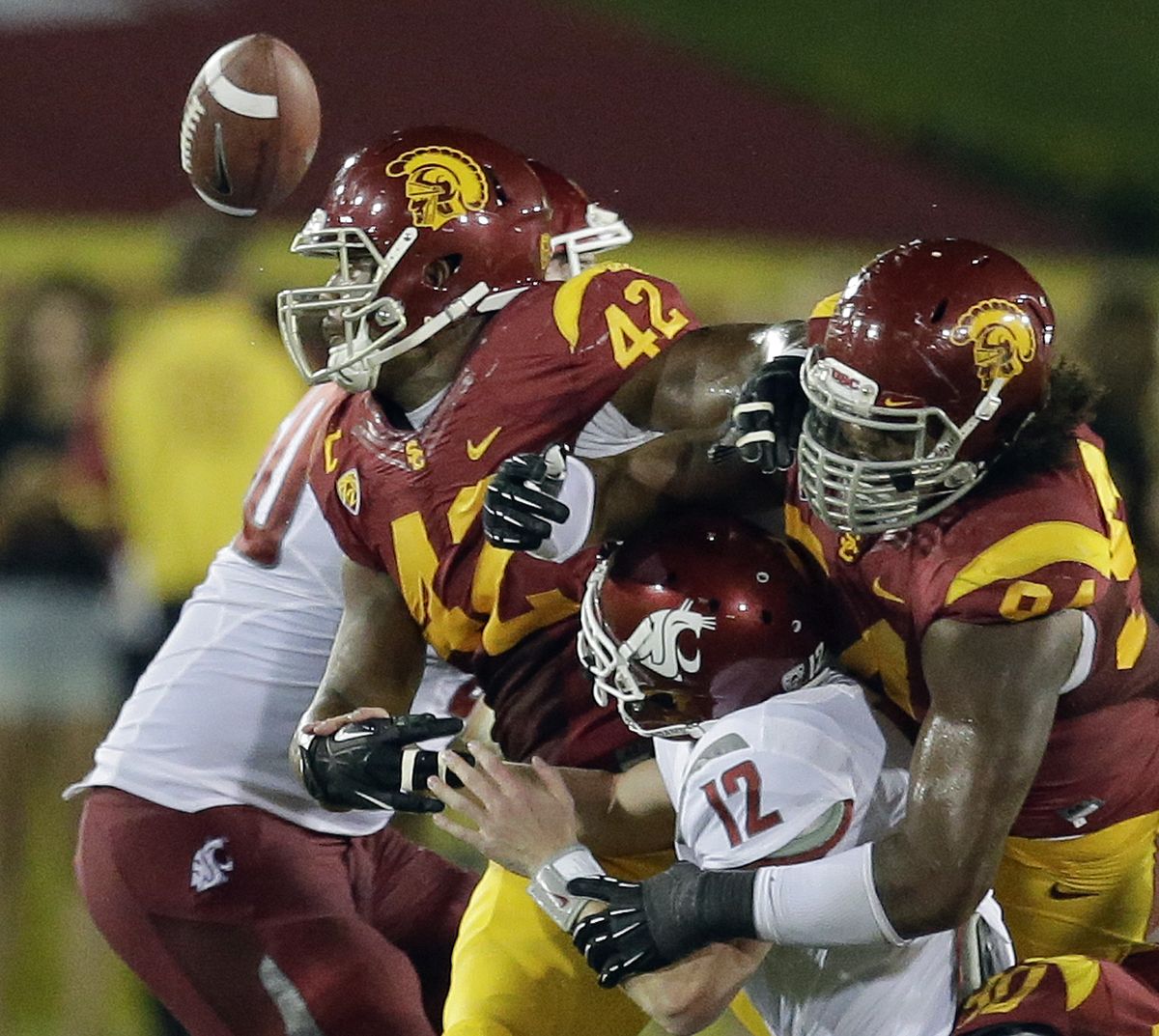 WSU quarterback Connor Halliday, middle, is stripped of the ball. (Associated Press)