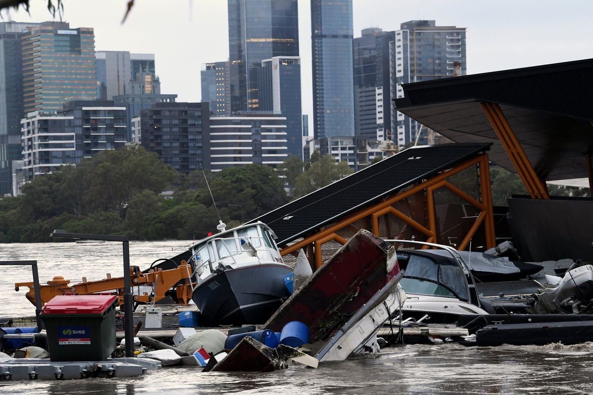 Boats and other debris are seen washed into the Milton ferry terminal on the Brisbane River in Brisbane, Australia, on Monday. Heavy rain is bringing record flooding to some coastal areas and claimed seven lives.  (Darren England)