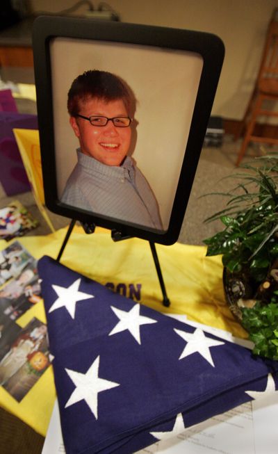 A photograph of Scott Charlson is shown next to the flag his family received from the U.S. Forest Service on Monday.  (Associated Press / The Spokesman-Review)