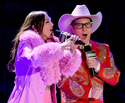 From left, Elle King and Rob Schneider speak onstage for New Year's Eve Live: Nashville's Big Bash at Bicentennial Capitol Mall State Park on Dec. 31, 2023, in Nashville, Tenn.   (Getty Images)