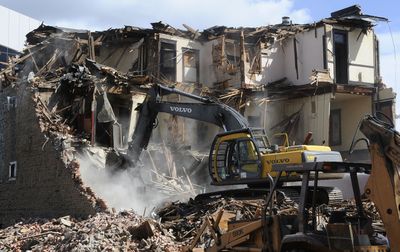 Larson’s Demolition Inc. takes a bite out of The Blvd. building Tuesday. The building was constructed in 1909.  (Dan Pelle / The Spokesman-Review)