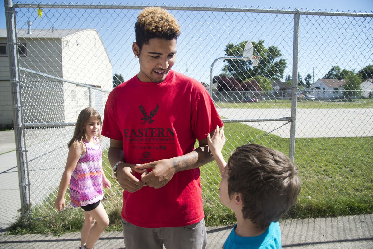 Tsai Ross, 18, talks with children in the play area of the Northtown Boys and Girls Club on Friday. Ross will graduate Saturday from Rogers High School. (Jesse Tinsley)