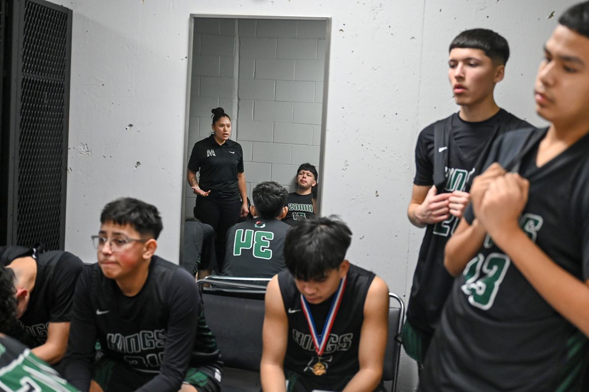 Muckleshoot Tribal Kings coach Dora Davis, reflected in a locker room mirror, tells her boys team to not hang their heads after a State 1B Boys Basketball Championship game defeat to Cusick Wednesday, Feb. 28, 2024, in the Spokane Arena. “Thank you for believing in me,” she said to the players.  (DAN PELLE/THE SPOKESMAN-REVIEW)