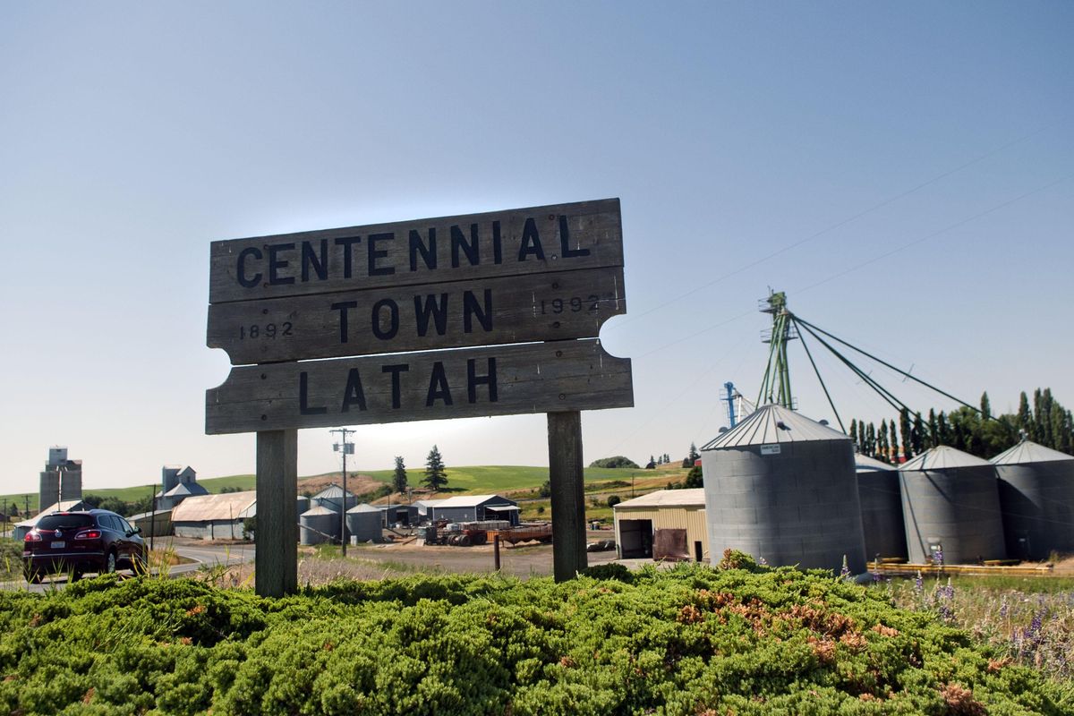 A car passes the Centennial Town sign in Latah on Wednesday, July 18, 2017. (Kathy Plonka / The Spokesman-Review)