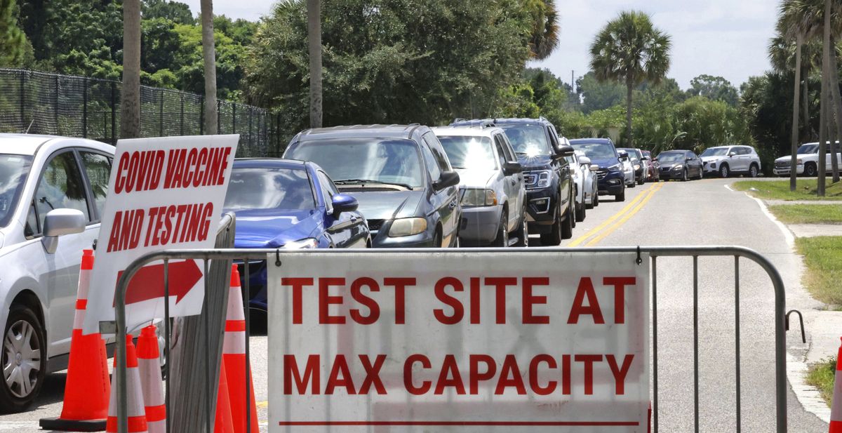 Signage stands at the ready (foreground) in case COVID-19 testing at Barnett Park reaches capacity, as cars wait in line in Orlando, Fla., Thursday, July 29, 2021. The line stretched through the park for more than a mile out to West Colonial Drive near the Central Florida Fairgrounds. Orange County is under a state of emergency as coronavirus infections skyrocket in Central Florida. The Barnett Park site is testing 1,000 people a day and has closed early in recent days due capacity limits.  (Joe Burbank)