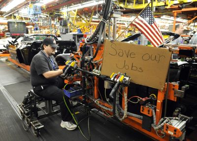 Mark Madden, a General Motors Corvette assembly plant worker, hangs a door on a car Friday at the Bowling Green, Ky., facility. Madden put a sign up at his work station when talks about helping the ailing auto industry began to fail. (Associated Press / The Spokesman-Review)