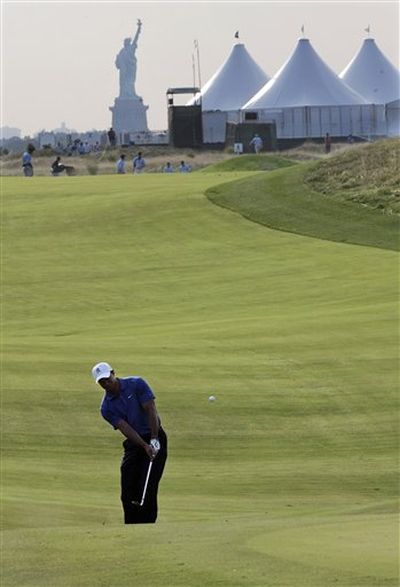 Tiger Woods chips to the third green, with the Statue of Liberty seen in the background, during a practice round for The Barclays golf tournament on Wednesday, Aug. 26, 2009, in Jersey City, N.J. (AP Photo/Mel Evans)

 (Mel Evans / AP News)