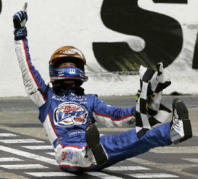 
Kurt Busch celebrates with the checkered flag on the finish line after winning the Food City 500 on Sunday. 
 (Associated Press / The Spokesman-Review)