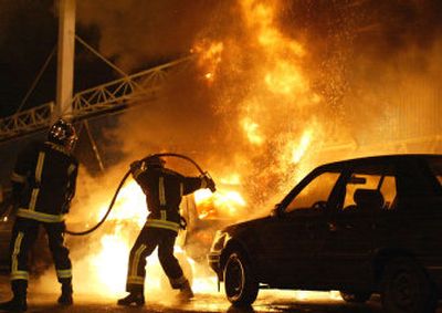 
Firefighters extinguish a fire in a burning car in Gentilly, south of Paris, on Tuesday. The current surge of violence in France started Oct. 27 as a localized riot in a northeast Paris suburb and has spread across the nation. 
 (Associated Press / The Spokesman-Review)
