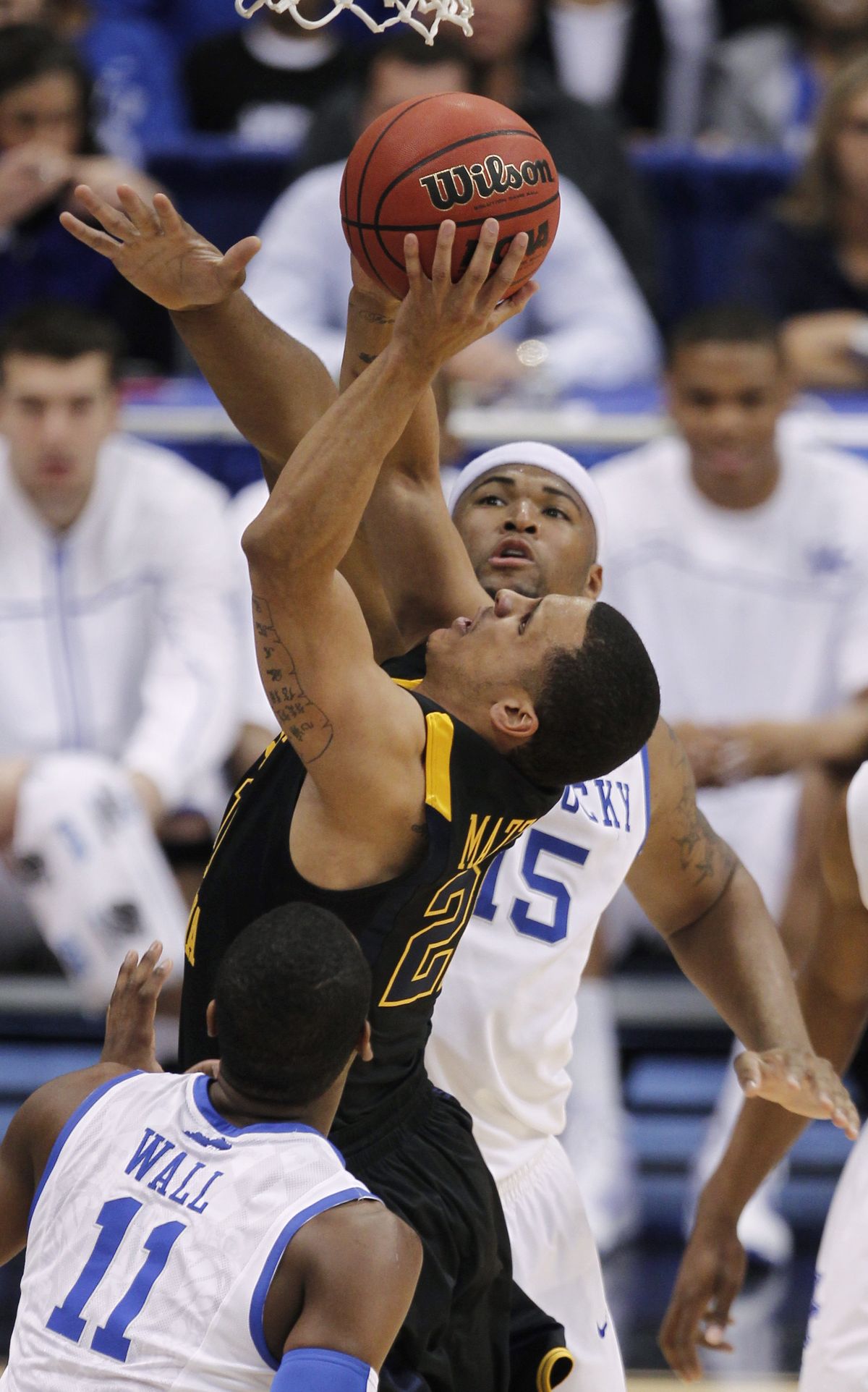 West Virginia’s Joe Mazzulla, drives between Kentucky’s John Wall, bottom, and DeMarcus Cousins during the first half of the final game in the East Regional.  (Associated Press)