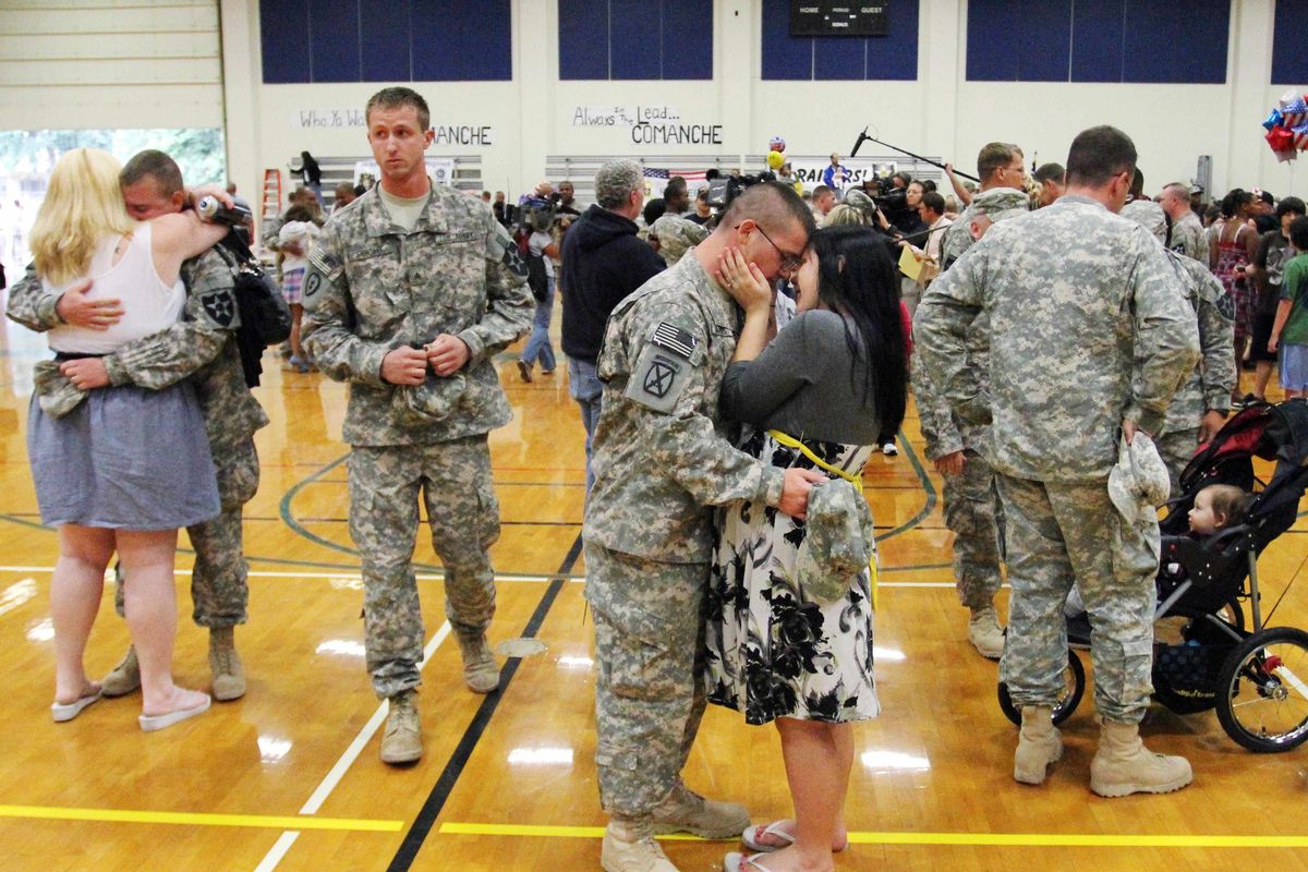 Couples embrace after about 150 soldiers from the Army