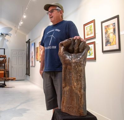 Artist Rick Davis stands next to his steel sculpture of a fist that was rejected by the city of Coeur d’Alene because some thought it was associated with protest, communistic or antimilitary movements of the past.  (Jesse Tinsley/THE SPOKESMAN-REVIEW)