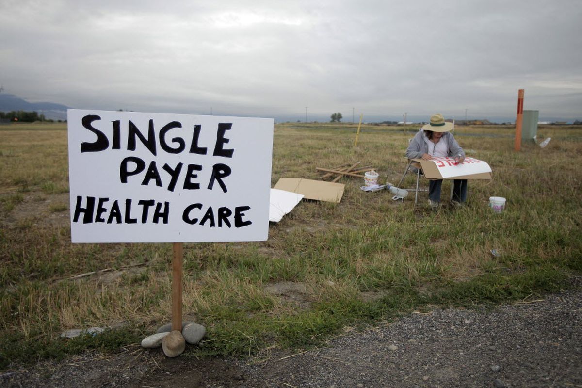 Linda Kenoyer, of the organization called Monantans for Single Payer, prepares signs near Gallatin Field Airport in  Belgrade, Mont., Friday, Aug. 14, 2009, where a town hall meeting with President Barack Obama will be taking place.  (Associated Press)