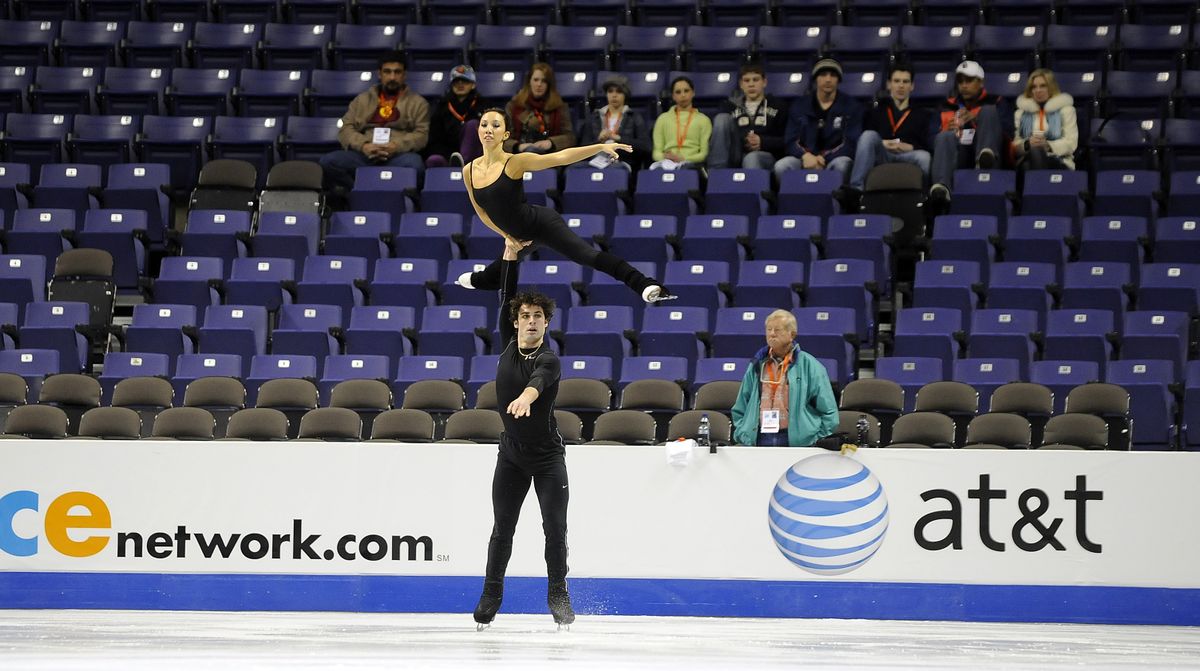 Rockne Brubaker lifts his partner, Keauna McLaughlin, as they work on their routine during a practice session at the Spokane Veterans Memorial Arena on Wednesday ahead of the U.S. Figure Skating Championships.  In the background in the green coat is their coach, John Nicks. (CHRISTOPHER ANDERSON)