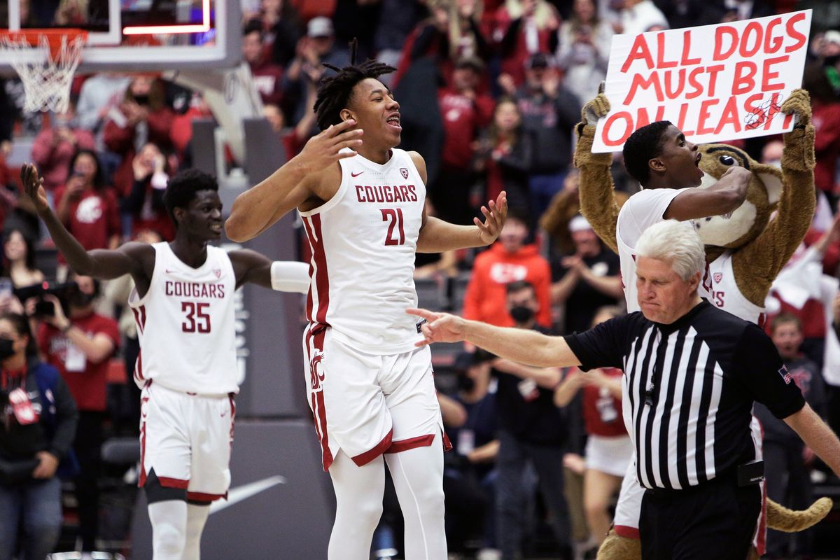 Washington State center Dishon Jackson, middle, forward Mouhamed Gueye, left, and guard Noah Williams celebrate the Cougars’ win over Washington on Feb. 23 in Pullman.  (Associated Press)