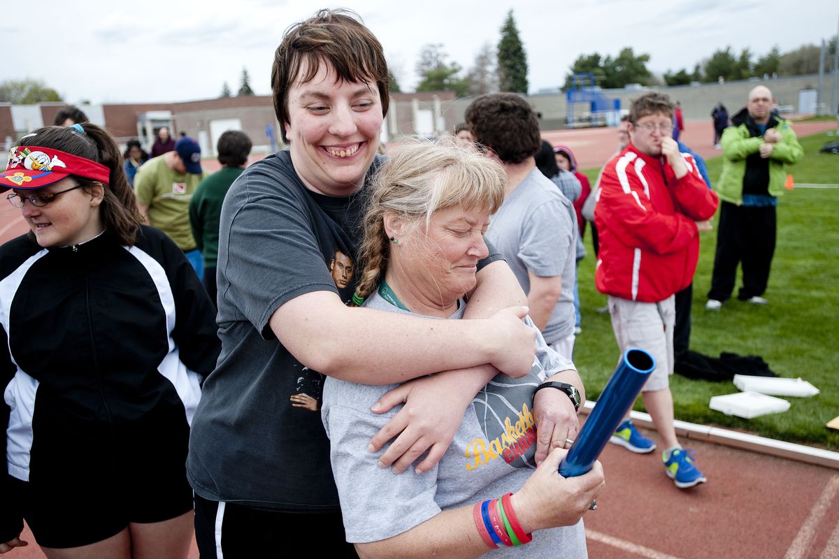Amanda Moore hugs teammate Robin Ainsworth, right, before they work on the 400-meter relay during a Special Olympics track practice recently at Spokane Community College. Amanda, who was born with autism, is featured in a video made by GU students to banish the R-word (retard and retarded) from our culture. (Tyler Tjomsland)