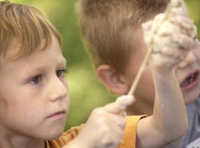 
Adam Taylor, 6, of Post Falls, makes a bread puppet using old bread, white glue and water at Falls Park in Post Falls on Monday. Taylor was one of about 50 children there as part of the Art on the EDGE  program. 
 (Photos by JOE BARRENTINE / The Spokesman-Review)