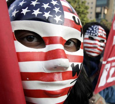 
WTO protesters wear anti-U.S. masks as they march in downtown Hong Kong on Sunday. The demonstrators chanted, 