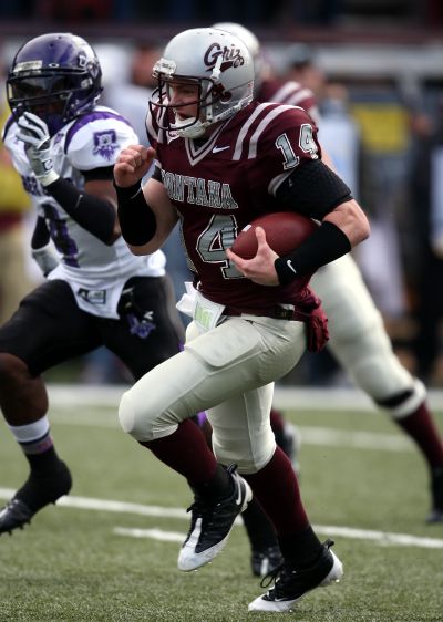 Griz quarterback Cole Bergquist runs for a touchdown as Weber’s Erik Stoll gives chase.  (Associated Press / The Spokesman-Review)