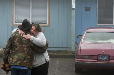 
Tracy Mitchell hugs her brother-in-law Rick Tilson, who was a neighbor of the children killed in a fire Monday. The fire killed three boys and injured two other children. 
 (Associated Press / The Spokesman-Review)