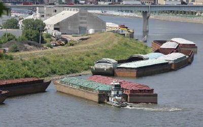 
A tugboat pushes two barges into place as empty barges begin to line the Mississippi River, in St. Paul, Minn. 
 (Associated Press / The Spokesman-Review)