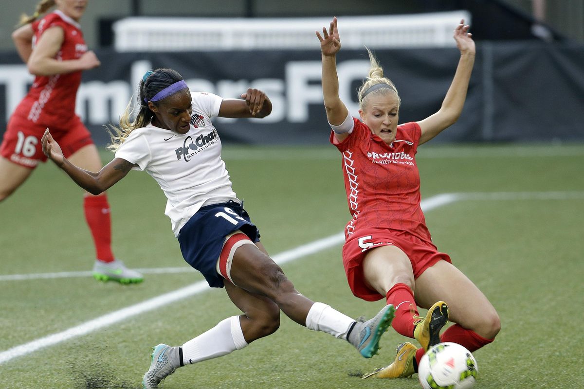 FILE - Crystal Dunn, left, takes a shot on goal for the Washington Spirit as Portland Thorns defender Kat Williamson dives in during the first half of an NWSL soccer match in Portland, Ore., Sunday, Aug. 30, 2015. The teams tied 3-3. (Don Ryan / Associated Press)