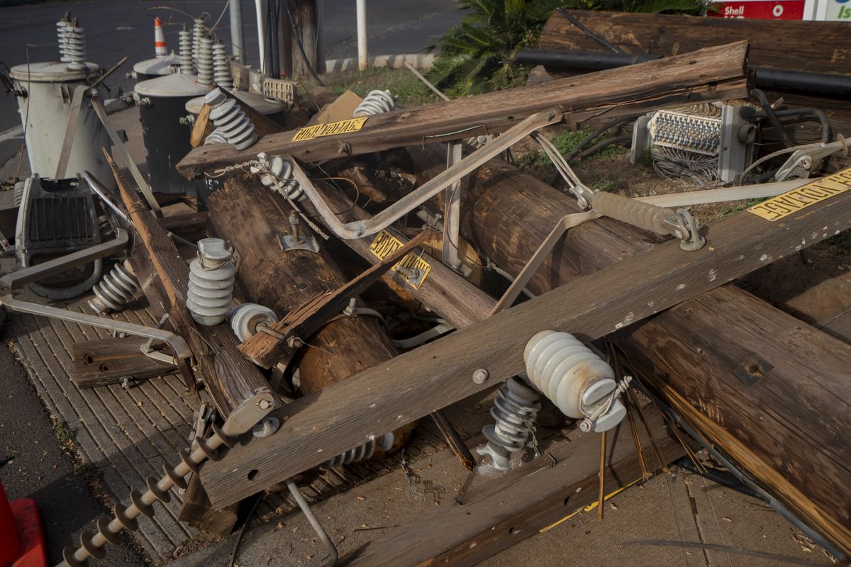 Fallen utility poles outside a gas station on Lahainaluna Road in Lahaina, Hawaii, on Aug. 21, 2023.    (Mengshin Lin/For The Washington Post)