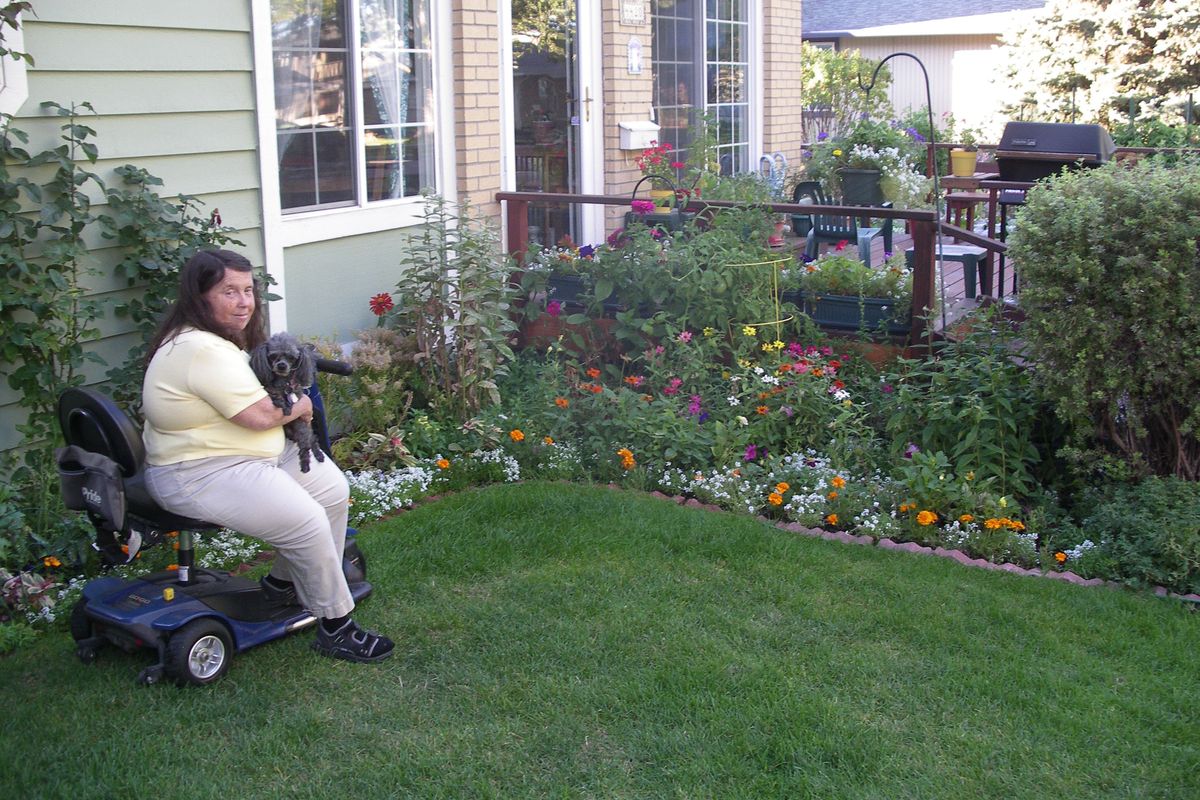 Jude Cromier and her garden helper Emily survey her award-winning garden at her South Hill condo. (Pat Munts)