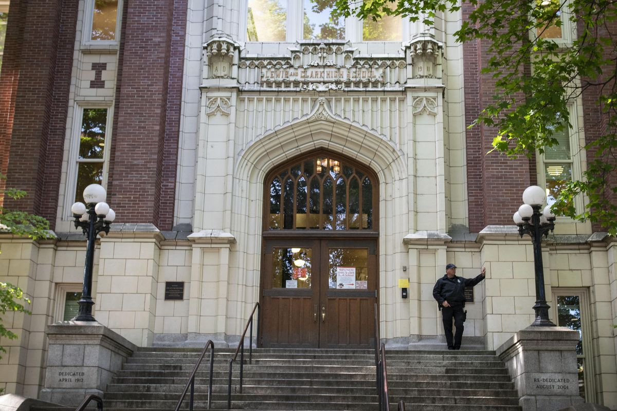 Spokane Police Officer Larry House stands sentry at the entrance of Lewis & Clark High School on Wednesday, May 30, 2018. There have been increasing security measures on campus in the wake of social media threats made on Tuesday. (Colin Mulvany / The Spokesman-Review)