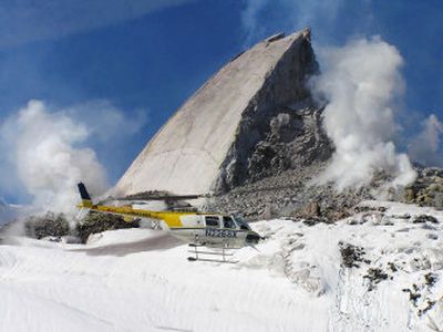 
In this photo provided by the U.S. Geological Survey, a helicopter flies past a new 