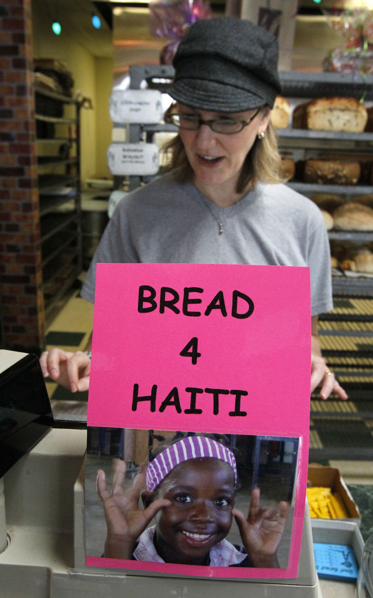 Shelli Volkmer rings up an order with a Bread 4 Haiti donation jar in front of the cash register last month in Stow, Ohio.
