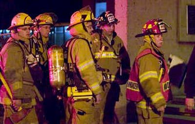 Firefighters watch investigators leave one of the Stephenson Hall towers on Washington State University campus early Monday. Associated Press
(Associated Press / The Spokesman-Review)