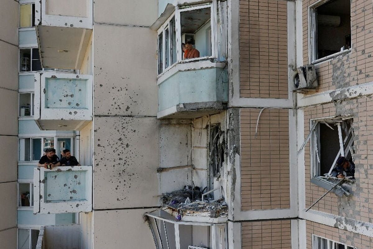 Residents clear debris from broken windows in a damaged apartment building following a Ukrainian drone attack in the course of Russia-Ukraine conflict on Sunday, in Krasnogorsk, in the Moscow region.   (Reuters )
