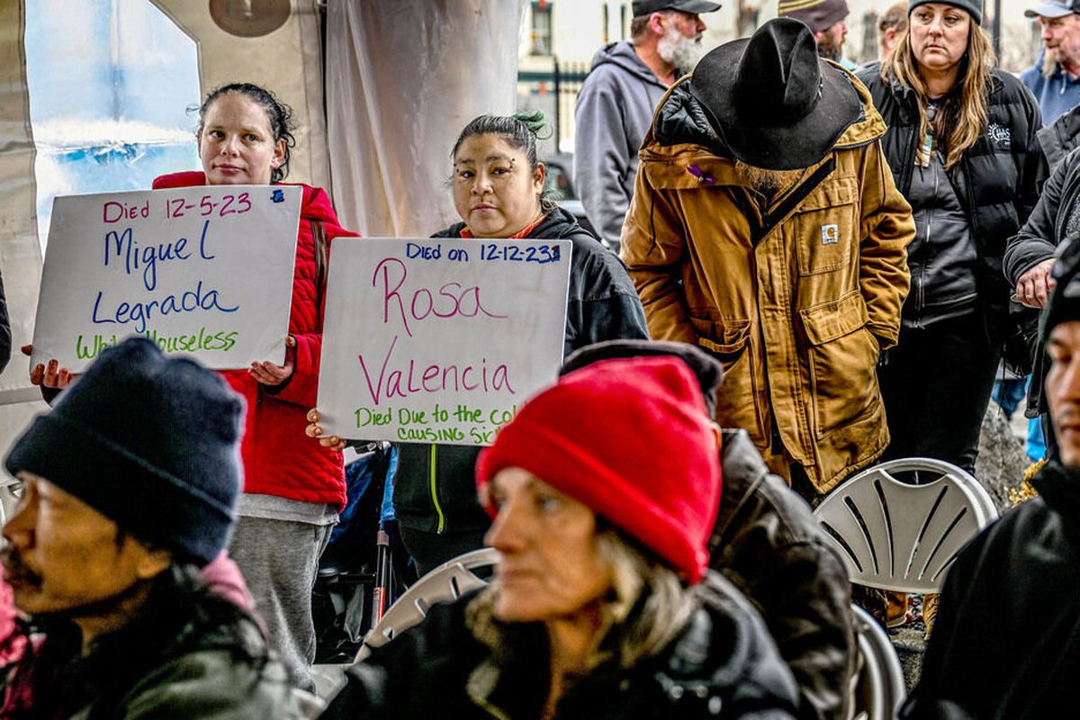 Keasha Rosenberg, left, and Misty Cree hold signs representing friends who have died during the Homeless Memorial event at CHAS Health/Denny Murphy Clinic on Thursday.  (Kathy Plonka)