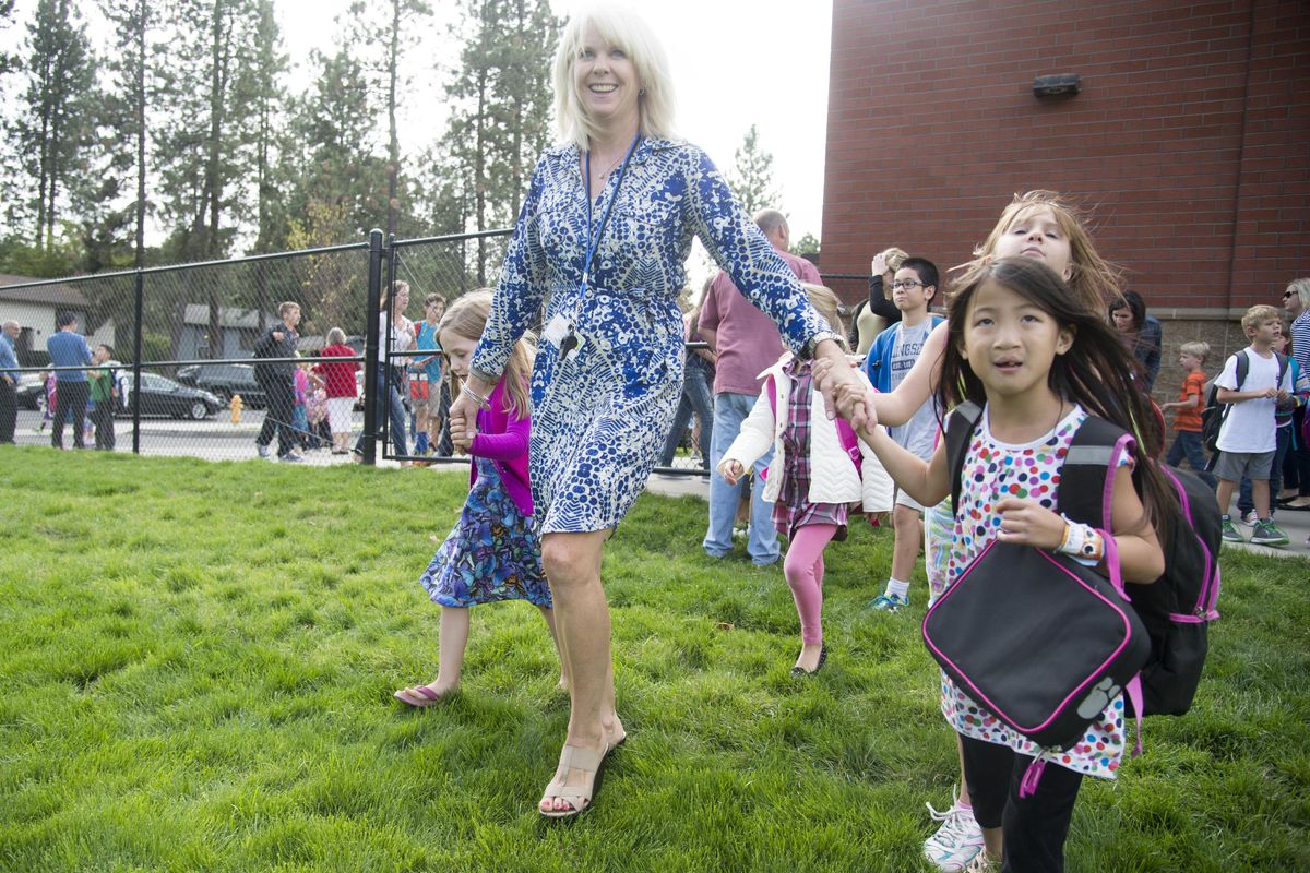 First-grade teacher Trish Campbell leads some of her students outside to find their buses after school Monday, Aug. 31, 2015 at Hutton Elementary. (Jesse Tinsley / The Spokesman-Review)