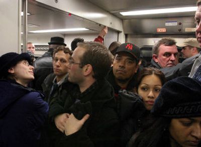 
Commuters stand shoulder-to-shoulder on a packed Long Island Rail Road train before it pulls out of New York's Penn Station on Wednesday. With bus and subway service shut down, New Yorkers flooded commuter train lines. 
 (Associated Press / The Spokesman-Review)