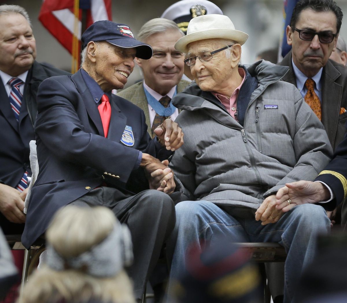 Television writer and veteran Norman Lear, right, shakes hands with Tuskegee Airmen Roscoe Brown during the annual Veterans Day parade in New York on Wednesday. The two served in the air force at the same time during World War II. (Seth Wenig / Associated Press)