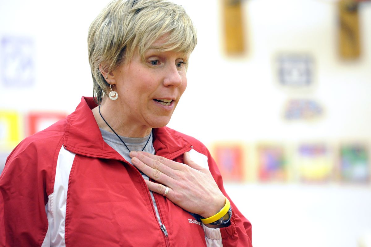 PJ Jarvis talks with her students about raising their heart rates with warm-up exercises at Opportunity Elementary School. (Jesse Tinsley)