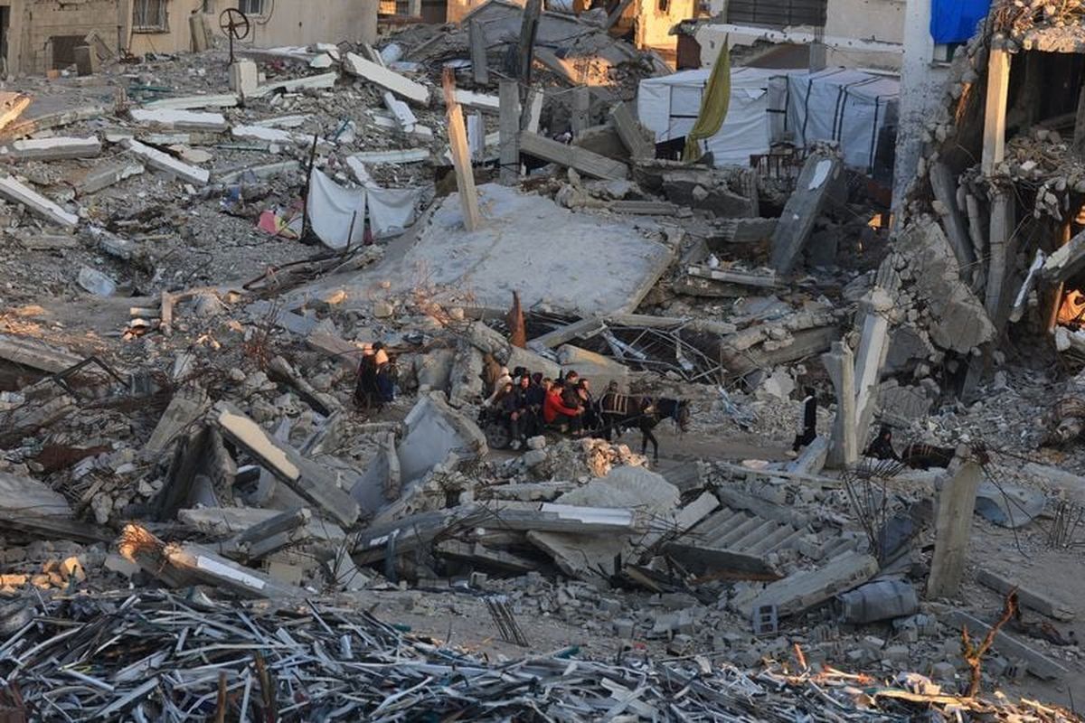 Palestinians move past the rubble of residential buildings destroyed during the war on Friday, in Gaza City.  (Reuters )