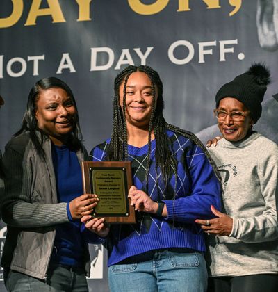 Genae Langford, center, accepts the Ivan Bush service award from MLK Center Director Freda Gandy, left, and Ivan’s wife, Fannie Bush, during the MLK Rally & March on Monday at the Spokane Convention Center.  (DAN PELLE/THE SPOKESMAN-REVIEW)
