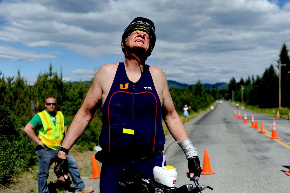 Tom Aylward, 62, grimaces as he nears completion of the 112-mile bike portion of the Ironman Coeur d’Alene competition on Sunday. (Kathy Plonka)