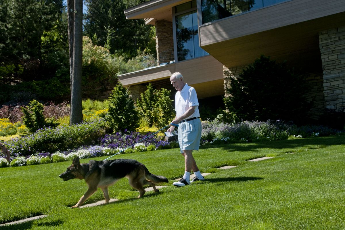 Duane Hagadone walks out with his german shepherd Winnie to greet visitors at his home at Casco Bay in Coeur d’Alene on Thursday, July 13, 2017.  (KATHY PLONKA)