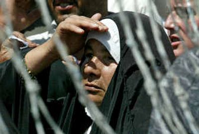 
An Iraqi woman peers through barbed wire outside the prison in Abu Ghraib, demanding to see her relative inside. An Iraqi woman peers through barbed wire outside the prison in Abu Ghraib, demanding to see her relative inside. 
 (Associated PressAssociated Press / The Spokesman-Review)