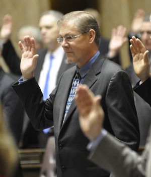 OLYMPIA -- Rep. Bob McCaslin, R-Spokane Valley, takes the oath of office on the opening day of the 2015 session. (Jim Camden)