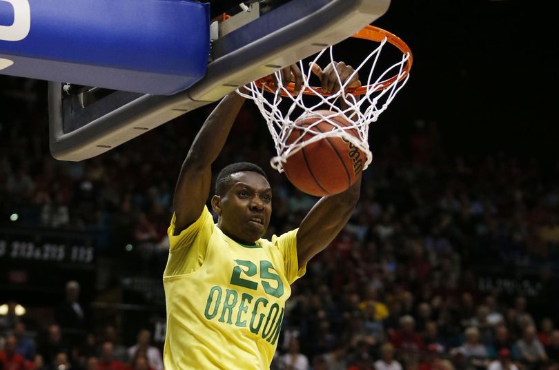 Oregon forward Chris Boucher dunks over Arizona forward Ryan Anderson (12) and center Dusan Ristic (14) during the second half of Friday’s Pac-12 Tournament semifinal. Oregon won in overtime, 95-89. (Associated Press)
